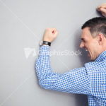 Angry man hitting wall