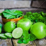 Green fruits and vegetables on wooden background