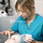 Nurse in a skin clinic applying protective cream