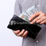 Hand pulling 100 dollars banknotes from wallet