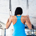 Rear view portrait of woman working out on gimnastic rings