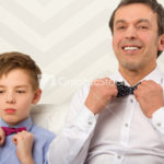 Father and son adjusting bowties
