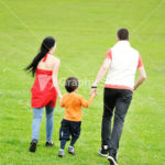 running family on green meadow in nature
