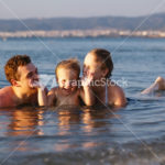 Laughing little boy with his parents at the sea