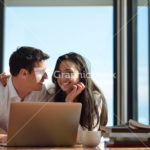 relaxed young couple working on laptop computer at home