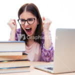 Angry woman sitting at the table with books and laptop