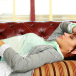 Tired woman sleeping on the coach at office