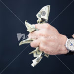 Businessman hand holding bills of US dollar in fist