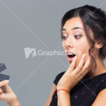 Amazed woman holding gift box