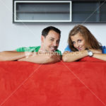 happy couple relax on red sofa