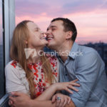 Young couple on the balcony embracing and laughing